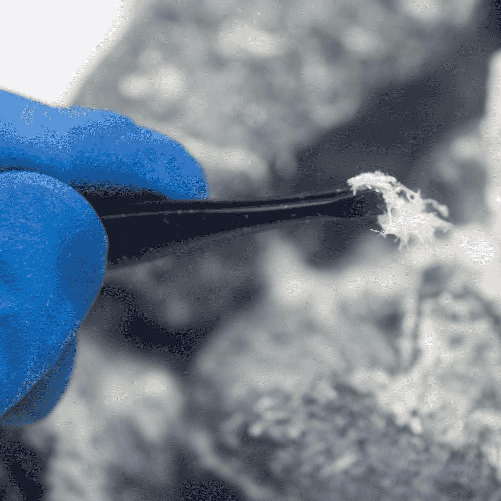 Inspector collecting an asbestos sample from an older Ottawa home for certified lab analysis.